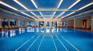 安塔利亚阿克拉酒店的大楼内带椅子的大型游泳池