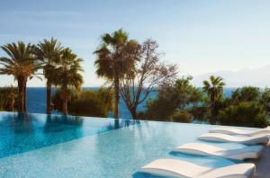 安塔利亚阿克拉酒店的享有大海和棕榈树景致的游泳池