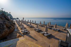 安塔利亚Akra Antalya的海滩上的一排椅子和遮阳伞