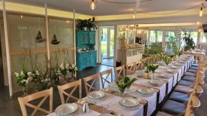 尼彻兹Akwamaryn Spa Niechorze的用餐室配有长桌子、椅子和鲜花