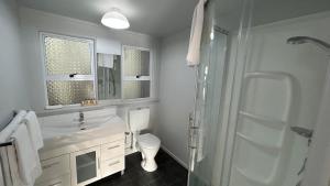 OakuraButlers Reef Accommodation的浴室配有卫生间、盥洗盆和淋浴。