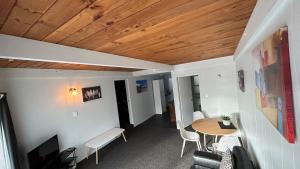 OakuraButlers Reef Accommodation的客房设有桌椅和木制天花板。