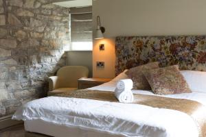 Two DalesSquare & Compass的一间卧室设有一张带石墙的大床