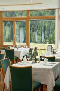 索尔达Hotel Cevedale的餐厅设有白色的桌椅和大窗户
