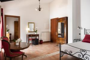 古比奥圣马可酒店的一间卧室配有一张床、一张桌子和一张书桌