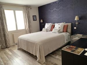 兰斯Les Suites Champenoises的一间卧室设有一张大床和一个窗户。