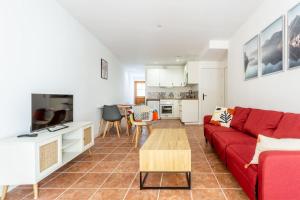 洛尔蒙Joli appartement avec jardin / Vieux-Lormont的客厅配有红色的沙发和桌子