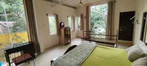 班加罗尔The Sunshine Bungalow的一间设有绿床的卧室,位于带窗户的房间内
