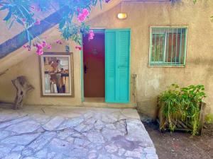 Bet ZayitLa Rustique Studio with a Spectacular View的一座带蓝色门和窗户的房子
