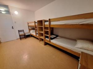 诺维格勒伊斯特拉Youth Hostel Pinesta的带三张双层床和椅子的房间