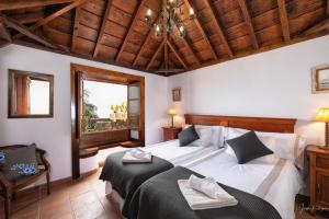 马佐Lightbooking La Morita Villa de Mazo con piscina的一间卧室设有两张床和木制天花板