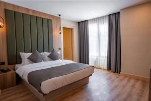 安塔利亚Perast City Hotel的一间卧室设有一张大床和一个大窗户