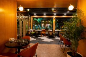 安塔利亚Perast City Hotel的一间设有桌椅的餐厅,种植了植物