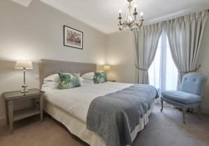 滨海博利厄保护区公寓的一间卧室配有一张床、一把椅子和一个吊灯。
