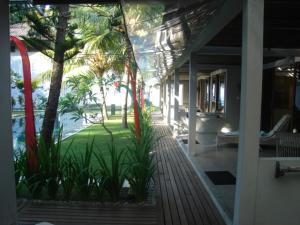 甘地达萨水族生态度假酒店的棕榈树和游泳池房子的门廊
