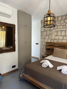 阿拉恰特Argente Alaçatı (Adult Only)的一间卧室设有一张床和石墙