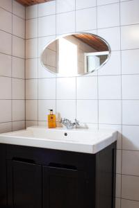 雷讷Authentic central located cabin close to Reinebringen Lofoten的一间带水槽和镜子的浴室