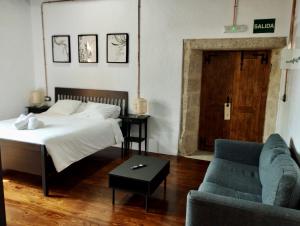 穆希亚Monasterio y Pensión de Moraime的一间卧室配有一张床、一张沙发和一张桌子