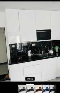 大格拉迪什泰Apartmani K&V的厨房配有白色橱柜和黑色台面