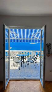 卢什蒂卡Casa di Zanjic的玻璃门通向带桌椅的天井