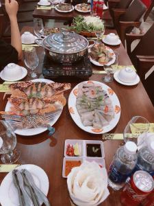 岑山Phương Thuỷ Hotel的一张木桌,上面放着食物盘