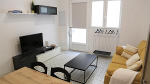 马德里Galileo apartment的客厅配有沙发和桌子