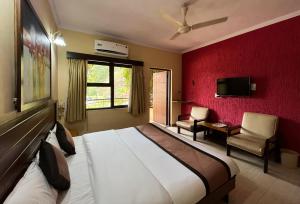 舍地Hotel Sai leela - Shirdi的一间卧室设有一张大床和红色的墙壁