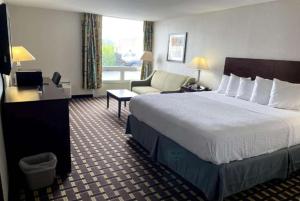 Fort Wright赖特堡/辛辛那提地区戴斯酒店的酒店客房带一张大床和一把椅子