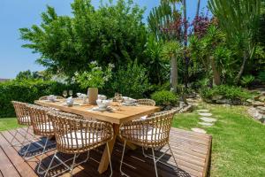 马贝拉VACATION MARBELLA I Villa Nadal, Private Pool, Lush Garden, Best Beaches at Your Doorstep的花园里的一张木桌和椅子