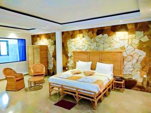埃拉Ella Dream Mount的一间卧室设有一张大床和石墙