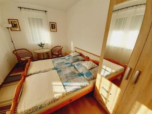 鲍洛通费尼韦什Hibiscus Nyaraló的一间卧室配有一张床、两把椅子和一个窗户