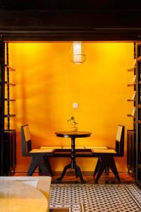 富国De Stefano Coffee and Hotel的黄色墙壁的房间里一张桌子和椅子