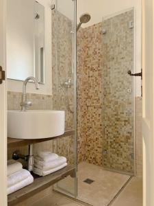 奥斯图尼Trullo Vicino al Mare的一间带水槽和玻璃淋浴的浴室