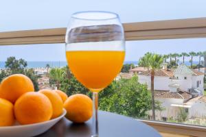 多列毛利诺斯Vistamarina A409 By IVI Real Estate的一杯橙汁,紧挨着一碗橘子