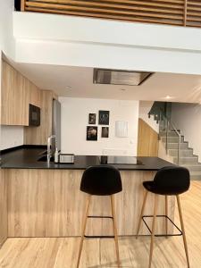 瓦伦西亚WeRentVLC - Espectacular Loft Duplex 1 hab的厨房配有黑色台面和黑色台凳