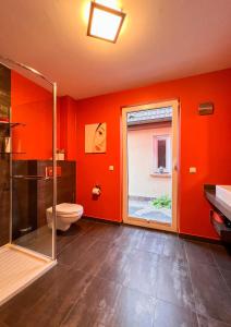 伊尔梅瑙Ferienhaus Conradshöh的浴室配有橙色的墙壁、卫生间和窗户。