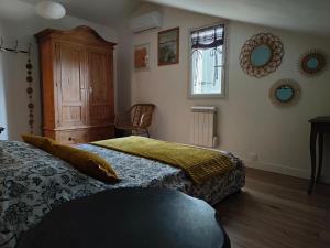 沙托雷纳尔Dolce Vita en Provence的一间卧室设有两张床、一个橱柜和一个窗口。