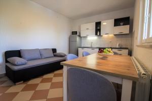 波尔Apartments Teskera的厨房以及带桌子和沙发的客厅。