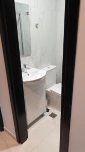 西洛卡特伦Evita Blue的一间带水槽、镜子和卫生间的浴室