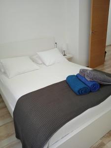 科斯塔特吉塞Blue View Hermoso Apartamento Remodelado Ubicación Ideal的一张白色的床,上面有两条蓝色的毛巾