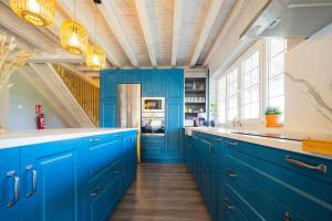 卢安科Las Cerezas Gozón的一间设有蓝色橱柜和大窗户的厨房