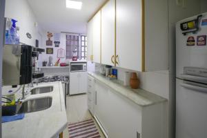 巴西利亚Apartamento ASA SUL的厨房配有白色橱柜和水槽