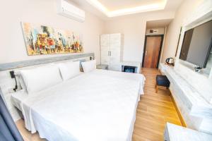 达特恰Feri Surf Club Hotel Datça的卧室配有白色的床和电视