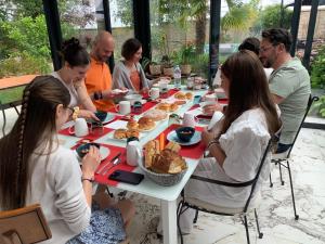 兰斯Les Suites Champenoises的一群坐在桌子旁吃食物的人