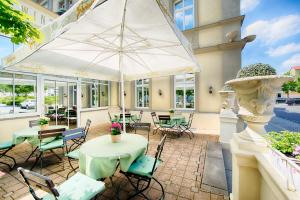 魏玛奥古斯特开森瑞酒店的一个带桌椅和遮阳伞的庭院
