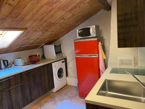 可利镇LA FAVELA的厨房配有红色冰箱和洗衣机