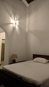 亭可马里Verandas Trincomalee的卧室配有一张床,墙上有灯