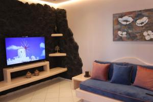 梅萨雷亚THE ROCK LUXURY HOMES的客厅配有蓝色的沙发和平面电视。