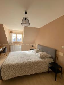 MontipouretGîte Les Tazons - Pays de George Sand的一间卧室设有床、窗户和一盏灯。