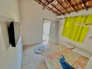 帕拉库鲁Pousada Casa Eco Paracuru的一间卧室配有一张床和一台平面电视